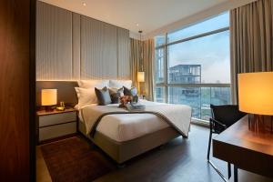 新加坡Ascott Orchard Singapore的一间带床和大窗户的酒店房间 更多37张照片