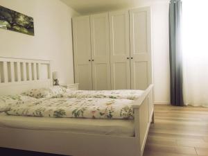 - une chambre dotée d'un lit avec un cadre blanc dans l'établissement Villa Wally, à Merano