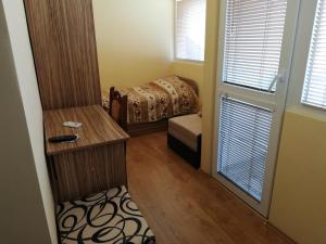 a small room with a bed and a window at Guest House Emi in Balchik