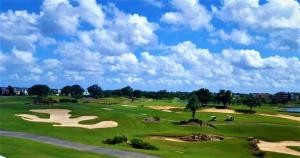 uma vista para um campo de golfe com pessoas nos verdes em Key 2 Indian Creek Pool Home em Kissimmee