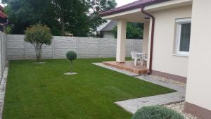 a small yard with a fence and a small tree at Rekreačný dom Flóra in Veľký Meder