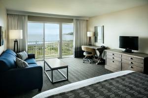 a hotel room with a bed and a view of the ocean at Beachfront Inn in Brookings