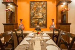 a dining room with a table with a lamp and vases at Hotel Marshyangdi in Kathmandu