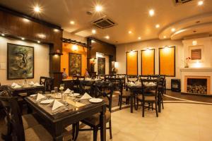 a dining room with tables and chairs and a fireplace at Hotel Marshyangdi in Kathmandu