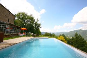 a large blue swimming pool next to a house at b&b LATORDICELLA in Castel del Rio