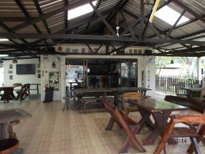 a restaurant with wooden tables and wooden chairs at Ryans Resort in Prasat