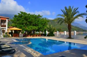 a swimming pool in a resort with mountains in the background at Ford Hotel in Adrasan