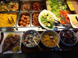 a buffet filled with different types of food in bowls at Hotel Dubrovnik in Dubrovnik