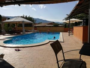 a swimming pool with a chair and an umbrella at Albergo Arinde in Rende