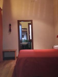 een slaapkamer met een rood bed en een spiegel bij Albergo Arinde in Rende