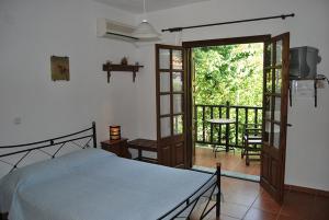 a bedroom with a bed and a balcony at Villa Katerina in Platanias