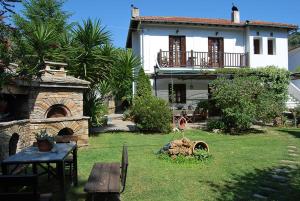 a large white house with a yard with a stone oven at Villa Katerina in Platanias