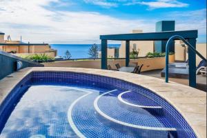 a swimming pool on the roof of a house at Beachfront Mooloolaba Apartment- 7th Floor Landmark resort in Mooloolaba
