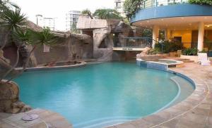 una grande piscina con cascata in un edificio di Beachfront Mooloolaba Apartment- 7th Floor in the Landmark Resort a Mooloolaba
