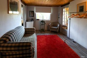 een woonkamer met een bank en een rood tapijt bij Moulin de Cocussotte in Saint-Pierre-sur-Dropt