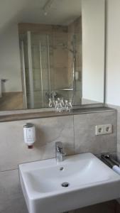プファッフェンヴァイラーにあるHotel Restaurant Engelのバスルーム(白い洗面台、鏡付)