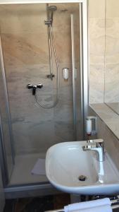 a bathroom with a shower and a sink and a shower at Hotel Restaurant Engel in Pfaffenweiler