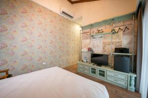 um quarto com uma cama e uma televisão de ecrã plano em R&J Guesthouse em Yuanshan