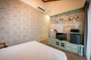 a bedroom with a bed and a flat screen tv at R&J Guesthouse in Yuanshan