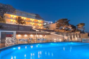 a pool in front of a hotel at night at Carian Hotel in Masouri