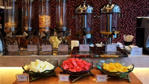 a buffet with bowls of different types of fruit at Metropolo Shenyang Wanda Plaza-Beiyi Road in Shenyang