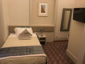 um quarto de hotel com uma cama e um espelho em Magione del Re em Catânia