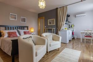 a bedroom with a bed and two chairs and a table at Apartments Mardešić in Komiža