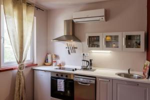 a kitchen with a sink and a stove at Apartments Mardešić in Komiža