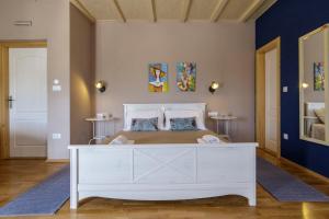 a bedroom with a white bed and blue walls at Apartments Mardešić in Komiža