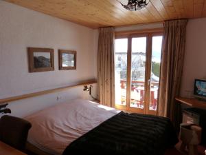 Un pat sau paturi într-o cameră la Hotel Ermitage Verbier