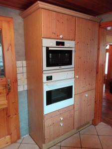 a kitchen with an oven in a wooden wall at Ferienzimmer Saatmann in Amorbach