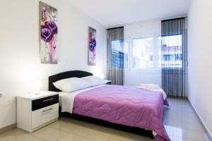1 dormitorio con 1 cama con manta morada en Apartments Kalelarga, en Zadar