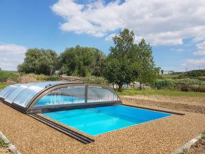 una piscina con techo de cristal en la parte superior de un campo en Apartmány U Ořecha, en Bořetice