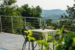 - une table avec deux verres de vin sur le balcon dans l'établissement Agriturismo Cascina Ponchietta, à Montà