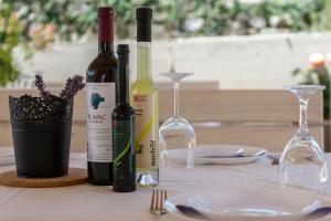 a table with two bottles of wine and two glasses at Apartments Mardešić in Komiža