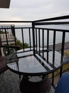 einen Glastisch auf dem Balkon mit Blick auf den Strand in der Unterkunft Apartment with sea view 37 in Kobuleti