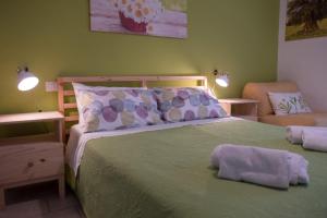 una camera con un letto verde e una sedia di My Room in Trani a Trani