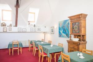 ein Esszimmer mit Tischen und Stühlen und einer Uhr in der Unterkunft Hotel Lauer in Schöneck