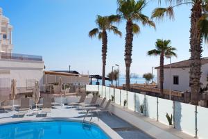 a view of the pool at the resort with palm trees at Apartamentos Ses Roquetes in Can Picafort