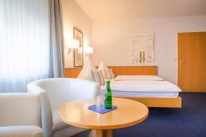 a hotel room with a bed and a bottle on a table at Hotel Lauer in Schoneck