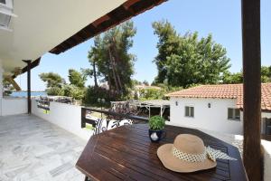 a wooden table with two hats on a balcony at Haus Platanos Apartments & Bungalows by the Sea in Vourvourou