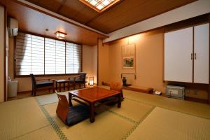 a living room with a table and a dining room at Ryokan Tamura in Kusatsu