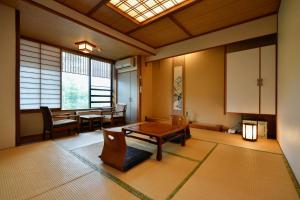 a living room with a table and a dining room at Ryokan Tamura in Kusatsu