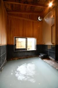 une chambre remplie d'eau dans une pièce avec fenêtre dans l'établissement Ryokan Tamura, à Kusatsu