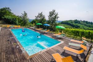 an outdoor swimming pool with chairs and umbrellas at Agriturismo Cascina Ponchietta in Montà