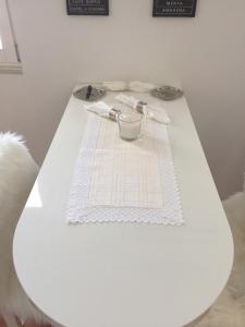 een witte tafel met een witte tafeldoek erop bij Studio apartman Karolina in Karlovac