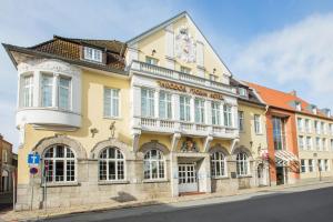 un edificio amarillo al lado de una calle en Best Western Plus Theodor Storm Hotel en Husum