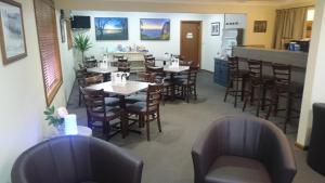 a restaurant with tables and chairs and a kitchen at Adelong Motel in Narrabri