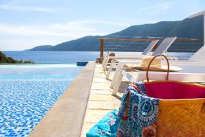 a pool with chairs and a view of the water at Sappho Boutique Suites in Vasiliki