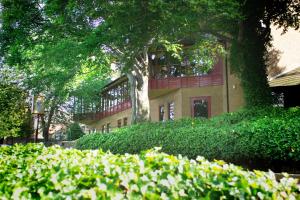 a building with a tree and bushes in front of it at The Gibside Hotel in Gateshead